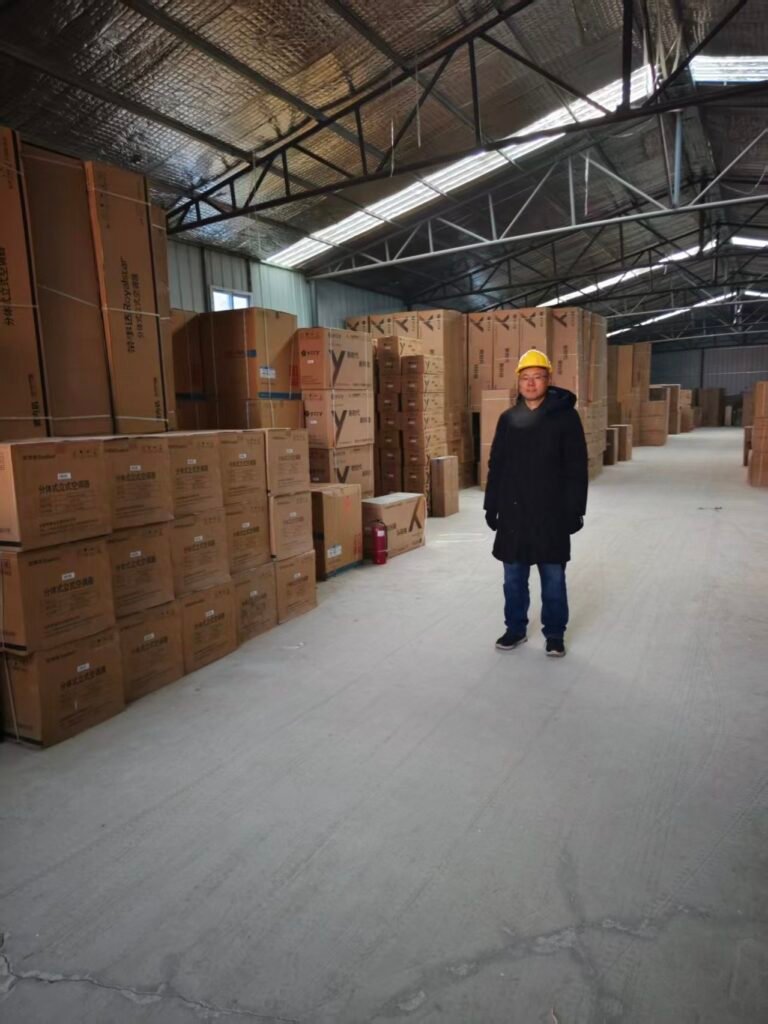 China Sourcing Expert Ray Wang wearing safety helmet at an appliance warehouse ready for shipment.