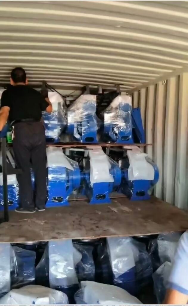 Workers loading blue feed crusher machines into 20 container - Efficient Packing