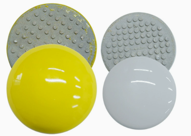 Glazed white and yellow ceramic road markers resistant to extreme heat and UV exposure in Middle East.