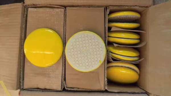 High-visibility yellow ceramic road stud with 20 tons compressive strength for highway safety.